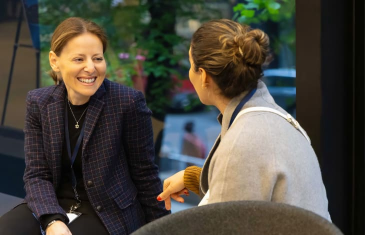 Two female team members of GRSM talking in the office.
